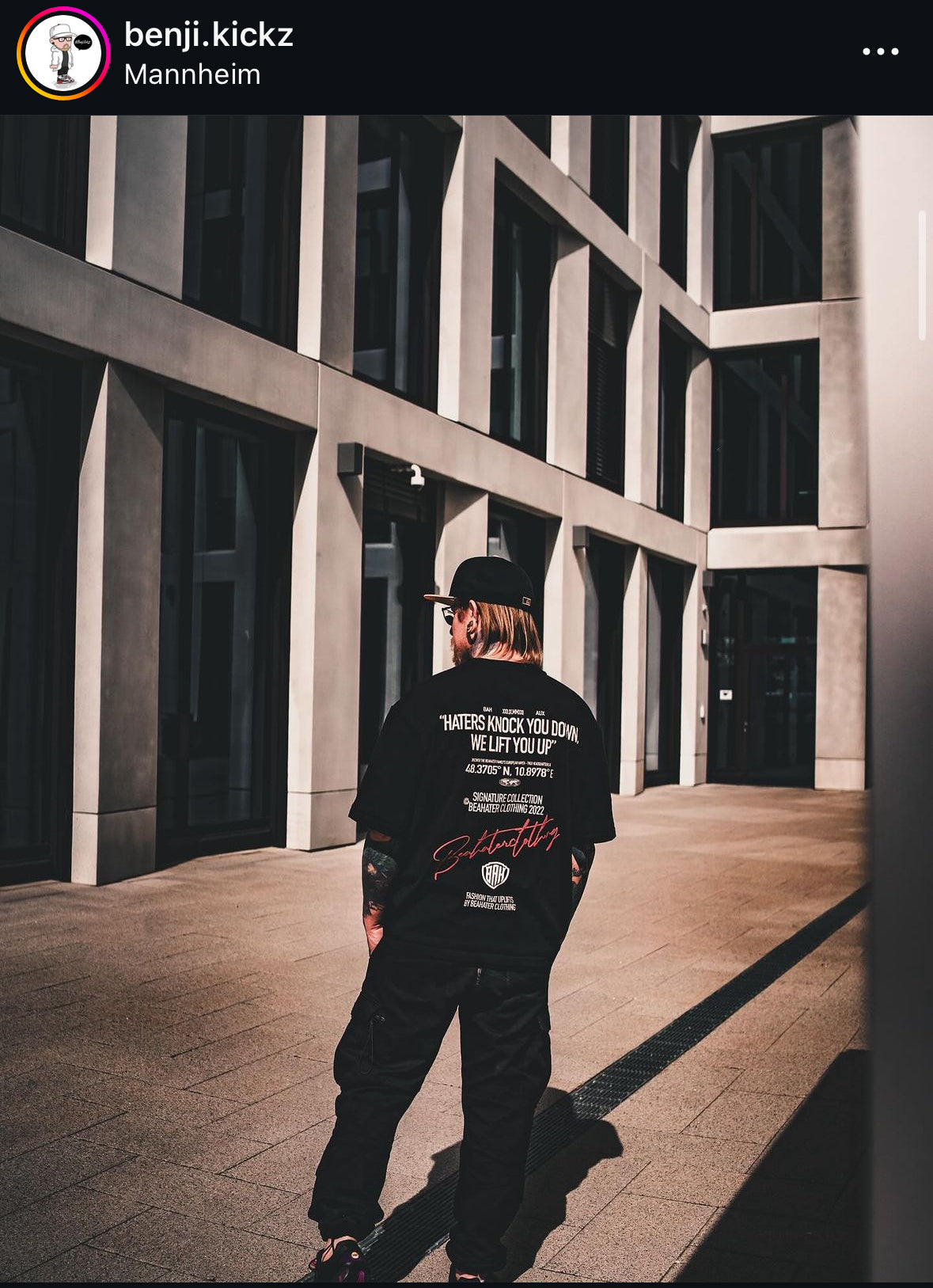 BEAHATER Clothing Oversize Streetwear T-Shirt in Schwarz mit Slogan ‚Haters Knock You Down‘ in urbaner Umgebung.